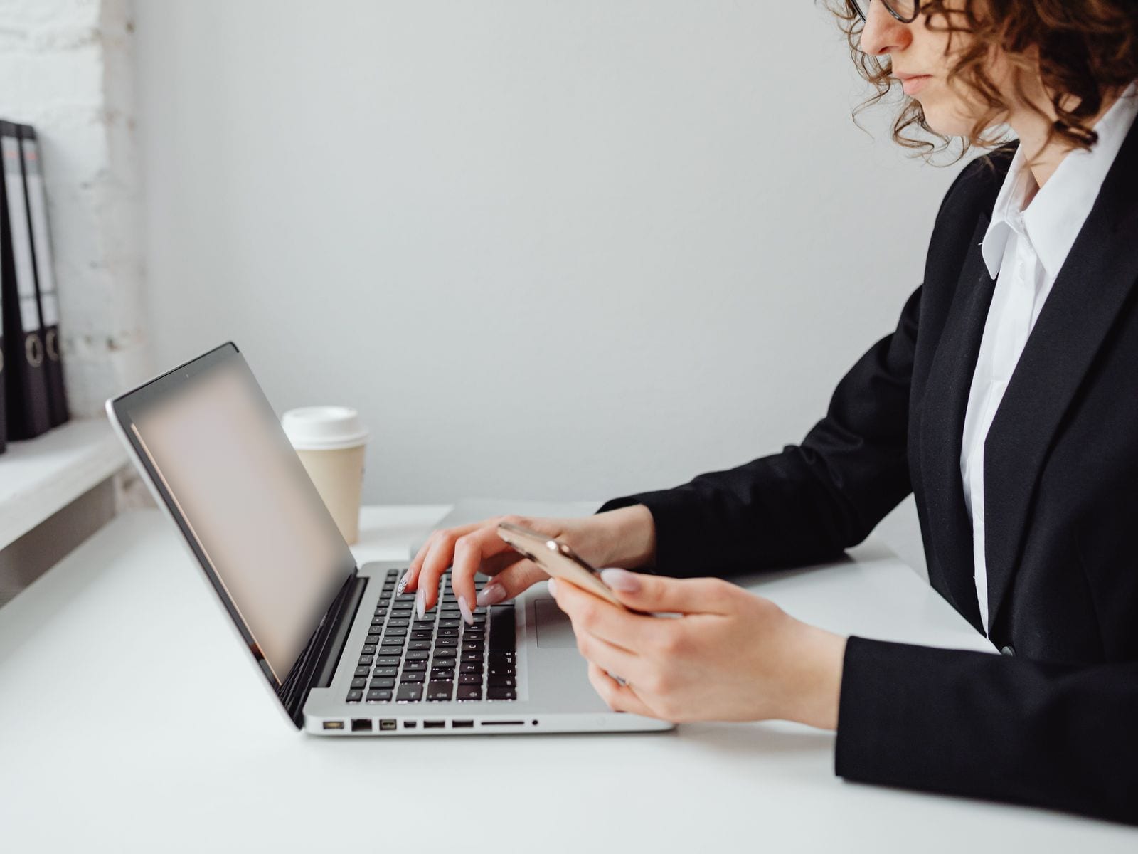 شخص يعمل على لابتوب وفي يده موبايل